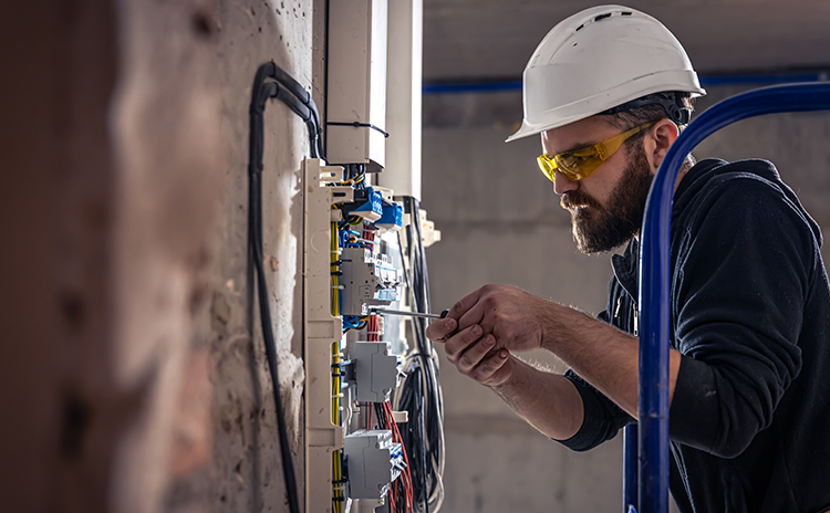 Electrical technician working on panel