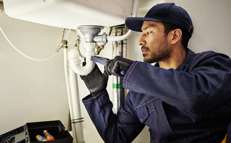 A plumber on a job scheduled with Zuper's plumbing scheduling software